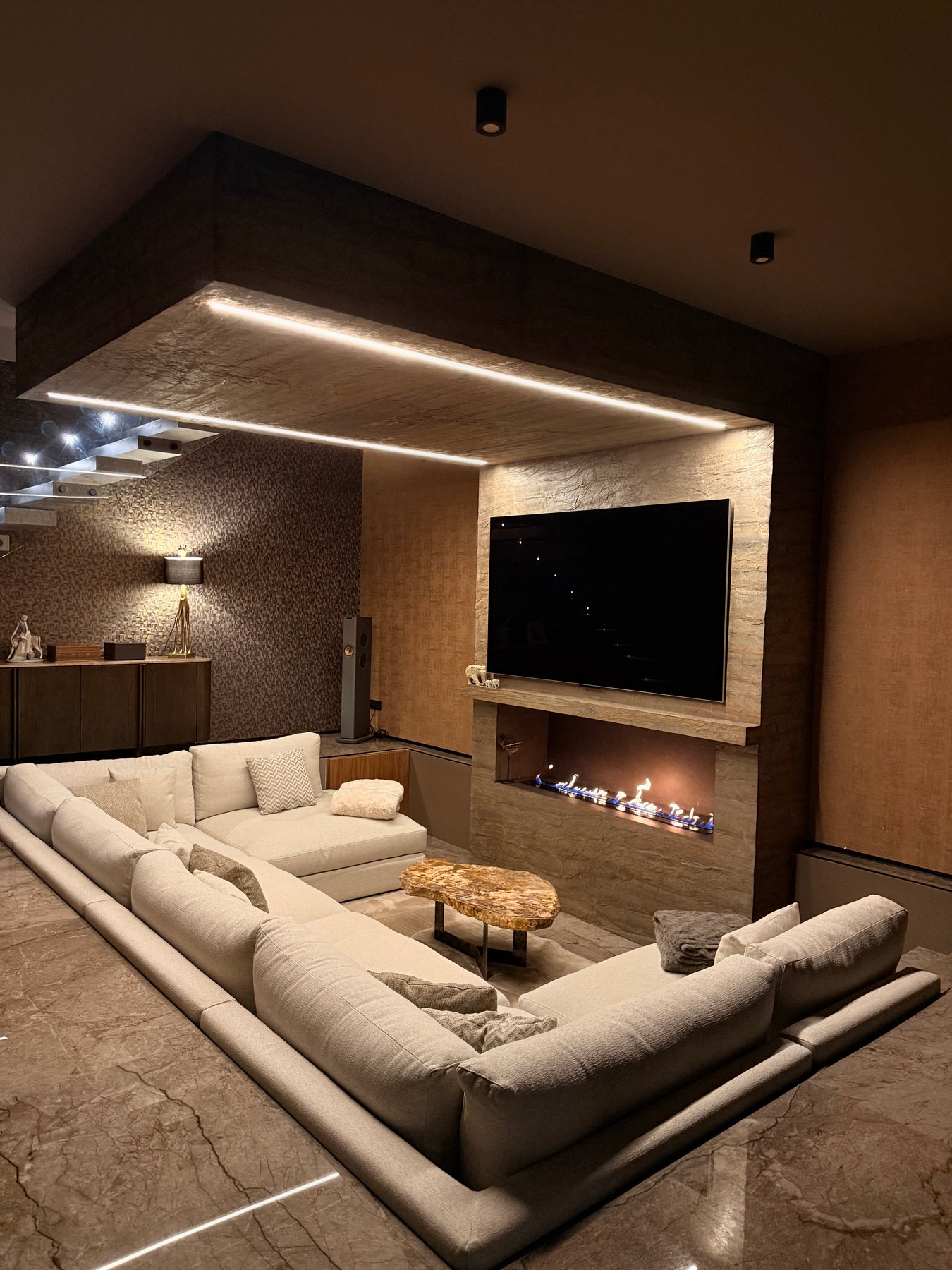 Salón de la casa terminada, con la chimenea y el gran sofá